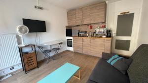 ein Wohnzimmer mit Couch und Küche in der Unterkunft Studio plein centre, calme, parking inclus, piscine et gardien in Grenoble