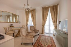 a living room with a tv and a table and chairs at Corte Realdi Suites Arena in Verona