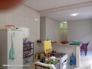 a kitchen with a stove and a refrigerator at EcoRupestre Hostel & Receptivo in São Raimundo Nonato