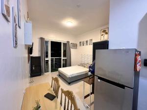 a room with a table and a refrigerator and a bed at Modena Town Square Minglanilla in Minglanilla
