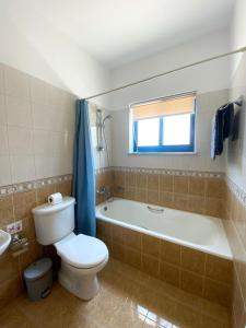 a bathroom with a toilet and a tub and a sink at STAY Lemon Marie Apartment in Ktima