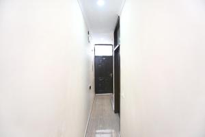 a hallway with a black door in a white wall at Hotel O Sky in Zirakpur