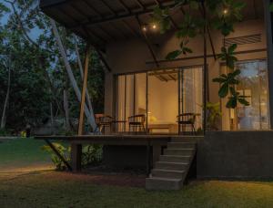 a house with a porch with chairs and a table at The Smiling Leaf in Ambalangoda