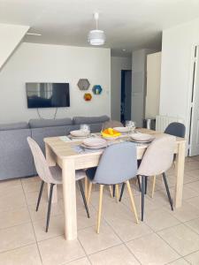 a dining table and chairs in a living room at Appartement Le Cap Trégor Centre Ville in Perros-Guirec +8 photos