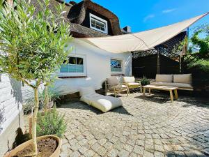 a patio with a couch and a table and a tent at Dat Reethus Helfsholm in Klamp