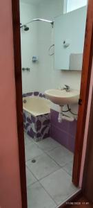 ein Badezimmer mit Waschbecken, Toilette und Spiegel in der Unterkunft Departamento El Mirador Concax in Los Baños del Inca