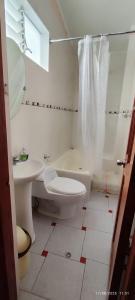 ein weißes Badezimmer mit Toilette und Waschbecken in der Unterkunft Departamento El Mirador Concax in Los Baños del Inca