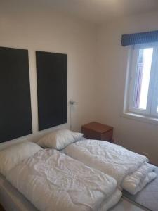 a bedroom with two beds and a window at Korshamn in Lyngdal