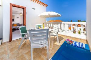 a dining table with chairs and an umbrella on a balcony at Apartment Paraiso Royal in Arona