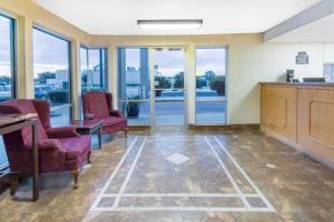 a lobby with chairs and a table and glass doors at Super 8 by Wyndham Seguin in Seguin