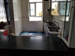 a small kitchen with a sink and a counter top at Hotel Kakh in Herāt