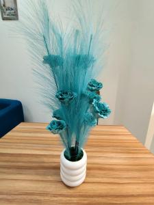 ドバイにあるDavid Empireの白花瓶の青い植物 +2枚の写真