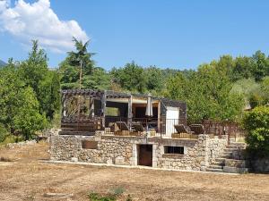 a stone house with a porch and chairs on it at Maison au calme absolue in Saint-Cézaire-sur-Siagne
