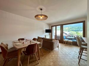 a dining room with a table and chairs with a view at Altitude Élégante - Centre Ville - WIFI - Balcon in Barcelonnette