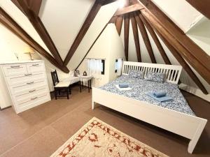 a bedroom with a large white bed and a desk at Szaletli in Tihany +32 photos