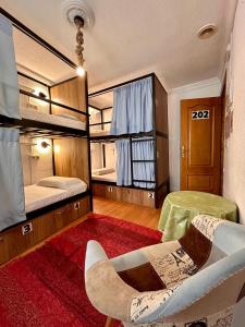 una habitación con dos literas y una silla en Hostel El Cascabel, en Granada