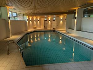 a large swimming pool with a tile floor at Apartment 9, Zentrumsnah mit Pool und Balkon in Bad Essen