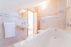a bathroom with a white tub and a sink at Apartments Sea View in Omiš