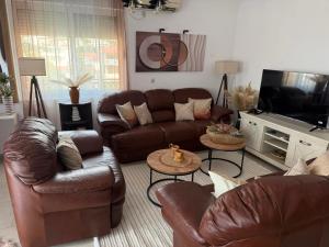 a living room with leather couches and a television at Lux Apartman David Dobra voda in Bar