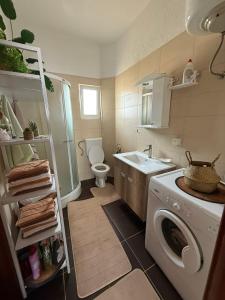 a small bathroom with a washing machine in it at Lux Apartman David Dobra voda in Bar +16 photos