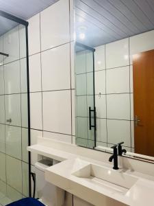 un baño con lavabo y espejo en Apartamento completo - COP30, en Ananindeua