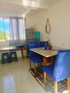a dining room with blue chairs and a table at Casa Aruna in Amontada