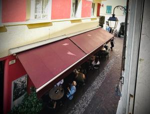 an overhead view of a restaurant with people sitting under awning at Casa Bors in Riva del Garda