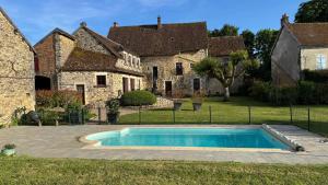 a swimming pool in the yard of a house at Maison Forte Perreuse in Treigny