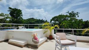 - Balcón con bañera de hidromasaje y silla en Melissatropical, en Las Terrenas