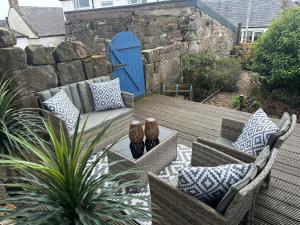 a patio with two chairs and a couch on a deck at The Place in Johnshaven