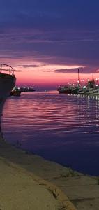 a sunset over a body of water with boats at Elegantia Domina apartment in the center in Fiumicino