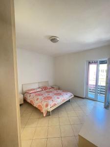 a bedroom with a bed in a room with a window at Palazzina Rosa in Spormaggiore