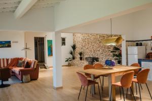 a dining room and living room with a table and chairs at Quinta do Sol Ocean Villa with Spa Bath & Volcano Views in Rabo de Peixe