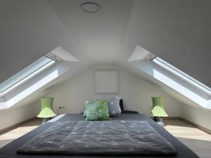 a bedroom with two skylights and a bed in a attic at Coole KreativWohnung zum Wohlfühlen in Wallenhorst