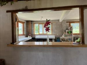 a kitchen with a vase of flowers on a counter at Cabaña El Descanso del Carpintero in La Marquesa