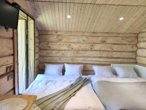 a bedroom with two beds in a wooden wall at Katase Guest House in Katase