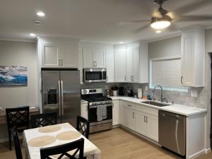 a kitchen with white cabinets and a table and a sink at Guest House in Torrance