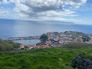 a small town on a hill next to the ocean at Casa do Nitsa in Corvo +4 photos