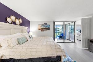 a bedroom with a large bed and a balcony at Steps To The Beach Loggerhead 472 in Sanibel +74 photos