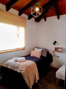 a bedroom with a bed in a room with a window at Casa Montanara in El Chalten