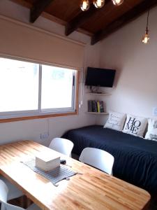 Habitación con mesa, cama, mesa y sillas. en Casa Montanara, en El Chaltén 9 fotos más