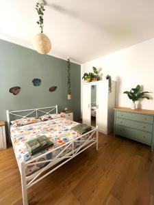 una camera da letto con un letto bianco e un pavimento in legno di B&B Sunny's House a Bologna Altre 8 foto