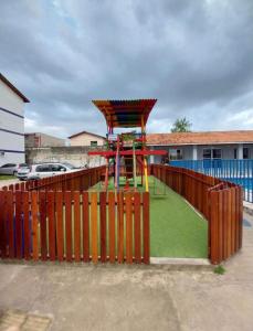 Un parque infantil con una valla de madera y un área de juegos en Apartamento completo - COP30, en Ananindeua 10 fotos más