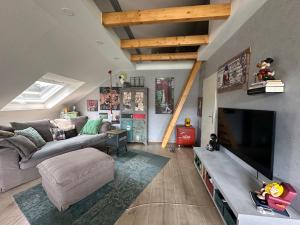 a living room with a couch and a tv at Coole KreativWohnung zum Wohlfühlen in Wallenhorst