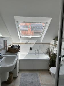 a bathroom with a sink and a tub and a window at Coole KreativWohnung zum Wohlfühlen in Wallenhorst +46 photos