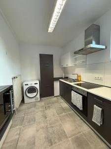 eine Küche mit Spüle und Waschmaschine in der Unterkunft Ferienwohnung Remscheid UHF in Remscheid + 13 Fotos