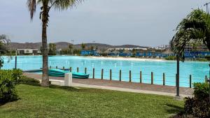 a large swimming pool with blue water and palm trees at Bluü Habitat with Beach and Premium Amenities in Mazatlán