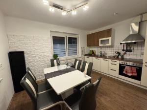 a kitchen and dining room with a white table and chairs at Urlaub mit Bergblick - Ferienhaus in Bad Bleiberg in Bad Bleiberg