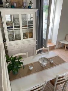 a white table and chairs in a kitchen with a hutch at Maison de famille proche du château et grande terrasse-jardin in Pornic