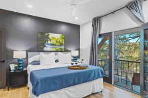 a bedroom with a bed with a blue bedspread at White & Black House 8br River in New Braunfels +200 photos